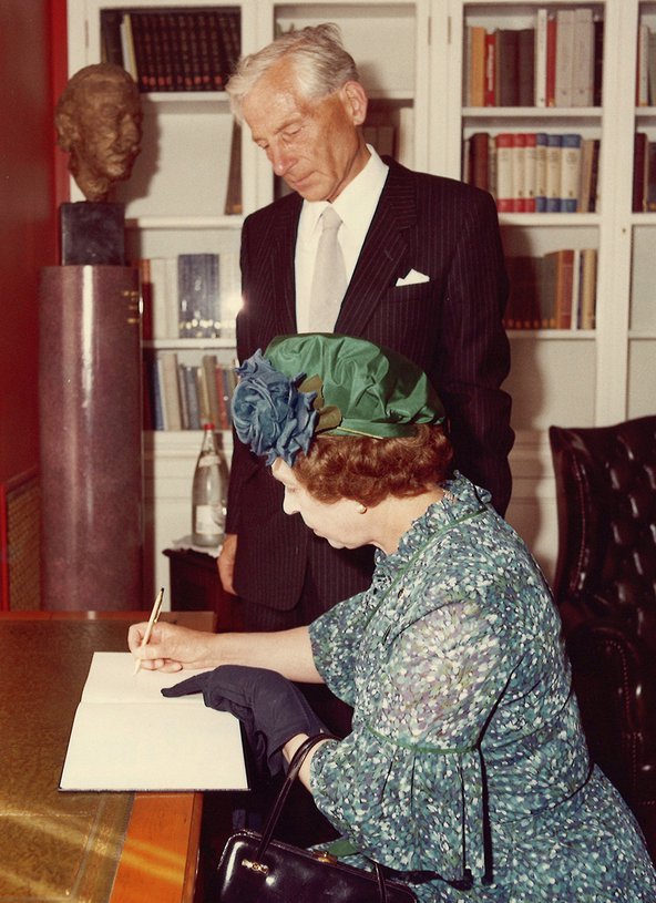 The Queen signs the guest book in the Library, in the company of the President of the British Academy, Revd Professor Owen Chadwick Kt.