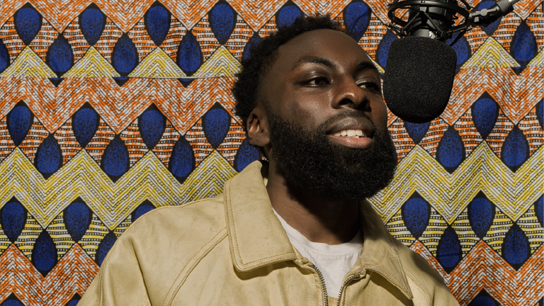 An image of Aniefiok Ekpoudom at a microphone