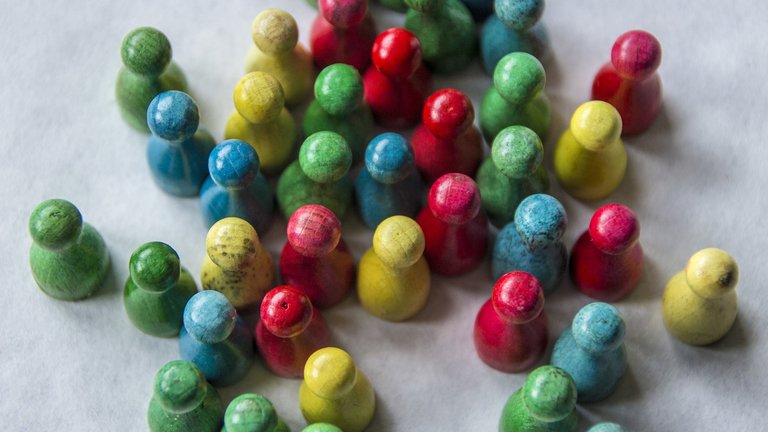 Colourful wooden pawns placed on a grey surface