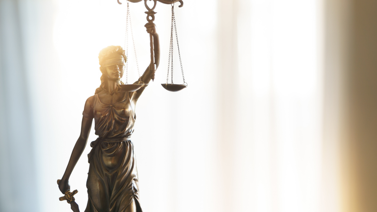 Statute of Lady Justice. Her attributes are a blindfold, scales, and a sword.