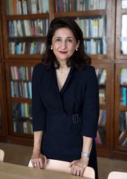 Photograph of Minouche Shafik with a bookcase in the background