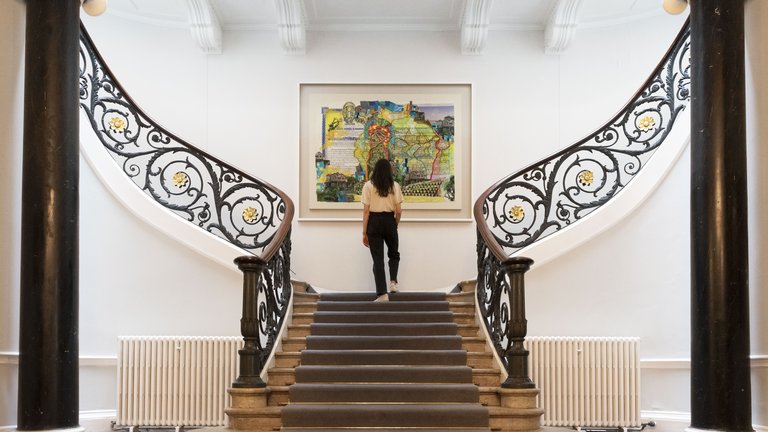 Photograph of the staircase in No.11 featuring Hew Locke painting