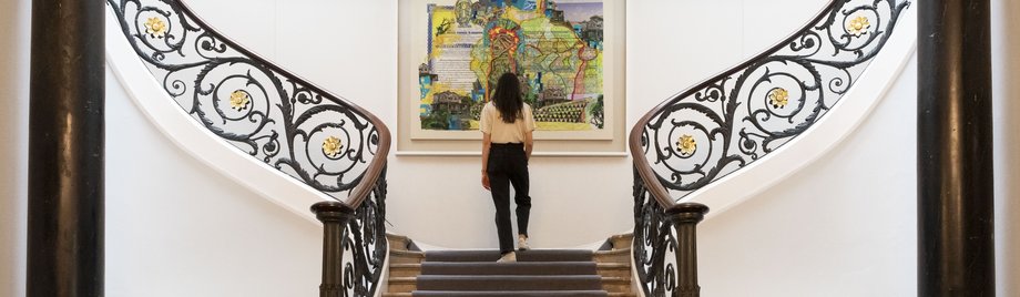 Photograph of the staircase in No.11 featuring Hew Locke painting
