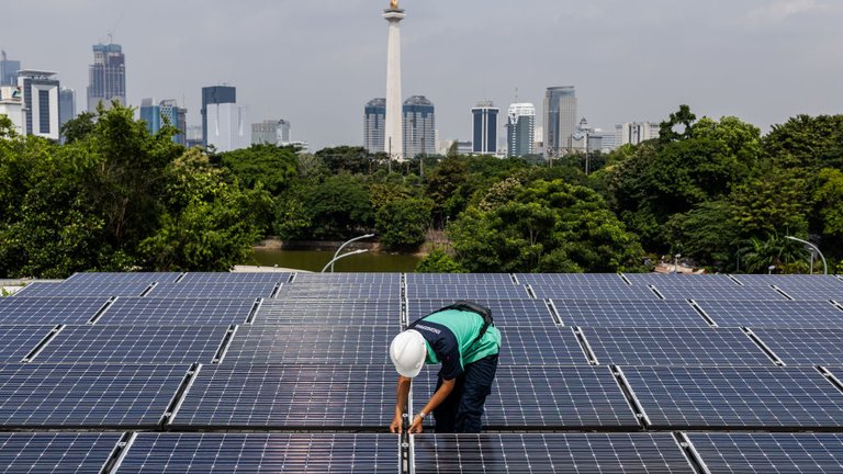 A worker inspecting a solar panel system