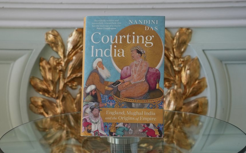 Landscape image of Nandini Das's book 'Courting India' propped up on a glass table