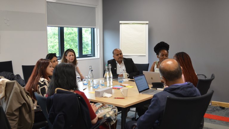 Group of people sat round a table at a conference