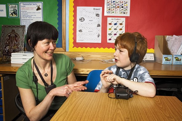 Deaf boy using sign language with teacher