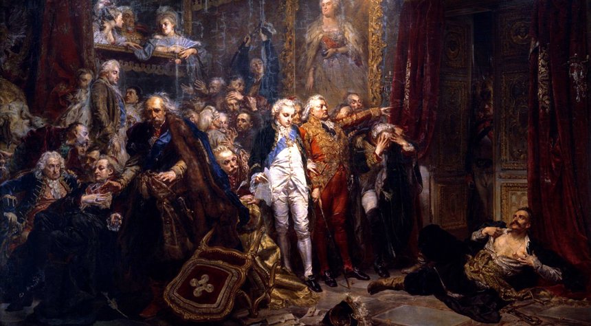 An oil painting by Jan Matejko Tadeusz Rejtan in a debate in the Sejm of the Polish-Lithuanian Commonwealth. A man dressed in red stands at the front of a crowd of parliamentarians with his arm raised in declamation. In the bottom right of the image, a man laying on the ground tears his shirt open to reveal his bare chest. A chair lies overturned in the foreground.