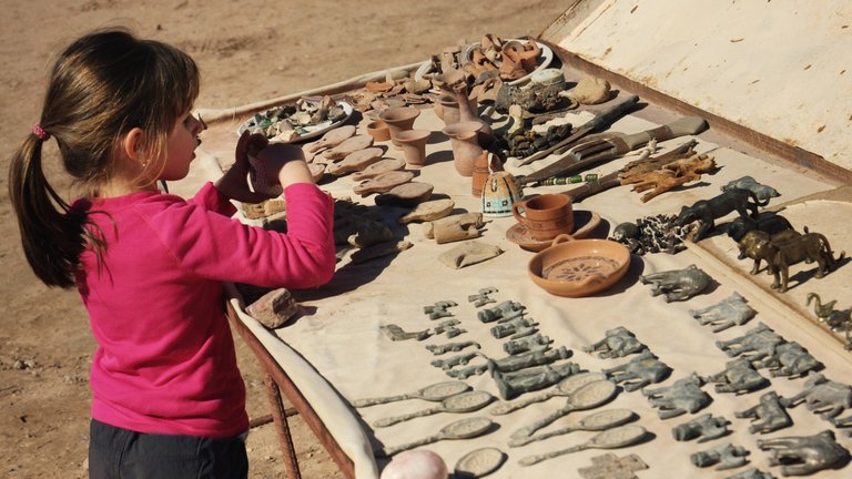 Concentrating adventurous girl looking for souvenirs from Petra in the sun