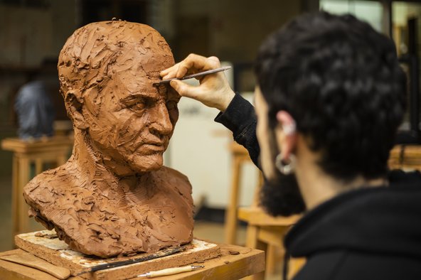 Sculptor finishing a clay head piece