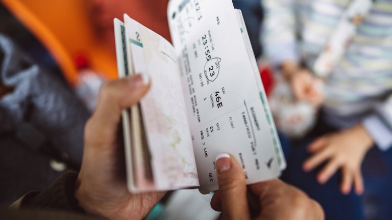 Close-up of someone opening up their passport with a ticket inside