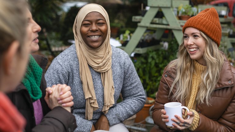 Image of people outside talking and sharing ideas whilst drinking tea