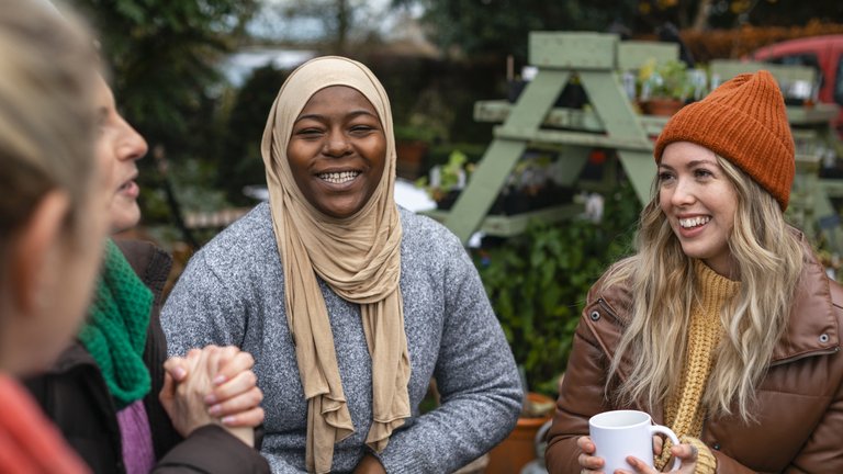 Volunteers sitting outdoors wearing warm casual clothing on a sunny cold winters day.