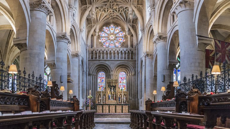 Majestic interior of Christ Church depicting stained glass, high ceilings and pews