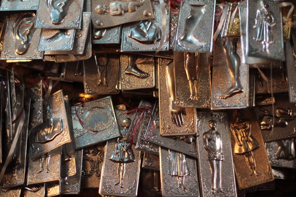 Votive offerings displayed in an Orthodox church in Crete. Each offering depicts a part of the body or a portrait of a person