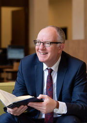 Photo of Richard Ovenden Hon-FBA sitting with an open book in his hands