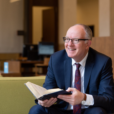 Photo of Richard Ovenden Hon-FBA sitting with an open book in his hands