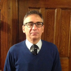 Javed Majeed standing in front of a wooden door