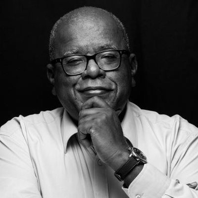Black and white photo of Jonathan Jansen FBA with his hand on his chin, looking into the camera