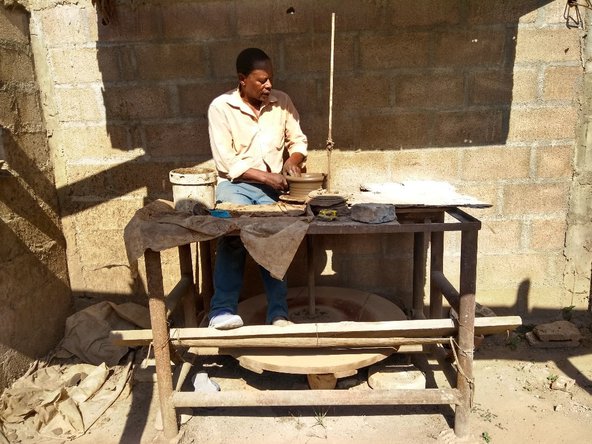 A man sits at a potter