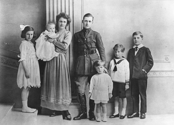 Nancy standing next to her husband, who's wearing a uniform, and their five children looking into the camera.