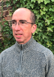 Headshot of Neil Kenny in front of greenery
