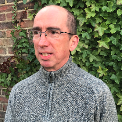 Headshot of Neil Kenny in front of greenery