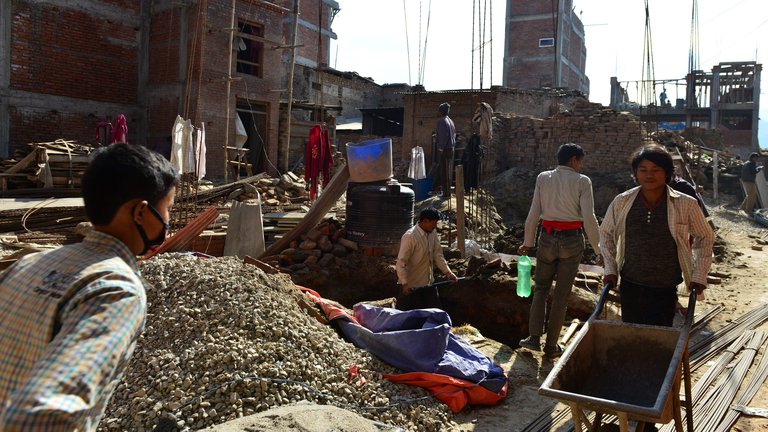 Nepalese labourers work on the reconstruction of a house on the outskirts of Kathmandu. Image credit: Prakash Mathema, AFP via Getty Images