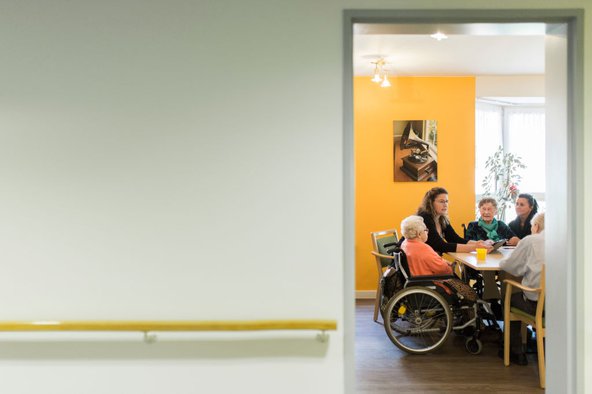 Residents of a nursing home in Berlin, Germany sit with carers. Photo by Florian Gaertner / Photothek via Getty Images