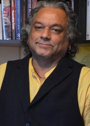 A photo of Subhabatra Banerjee in front of a bookcase