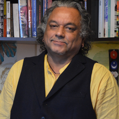 A photo of Subhabatra Banerjee in front of a bookcase