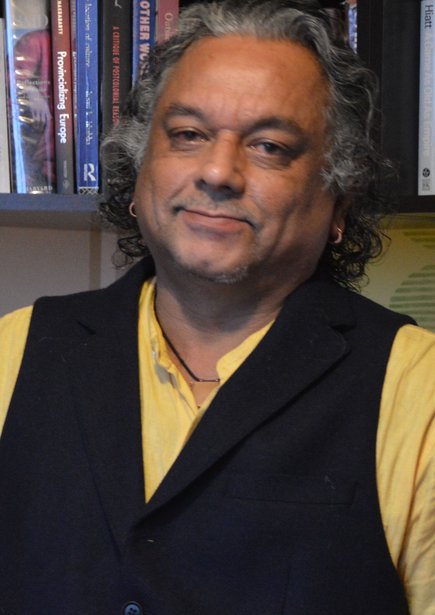 A photo of Subhabatra Banerjee in front of a bookcase