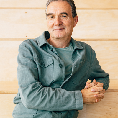 A portrait photo of Justin Lewis FBA in front of a panelled background.