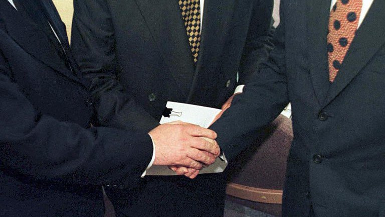 The handshake of Tony Blair (R) US Senator George Mitchell (C) and Irish Prime Minister Bertie Ahern (L) after they signed the historic agreement for peace in Northern Ireland.