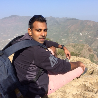 Professor Upamanyu Pablo Mukherjee FBA looking back over his shoulder at the camera with mountains in the background