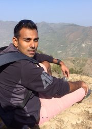 Professor Upamanyu Pablo Mukherjee FBA looking back over his shoulder at the camera with mountains in the background