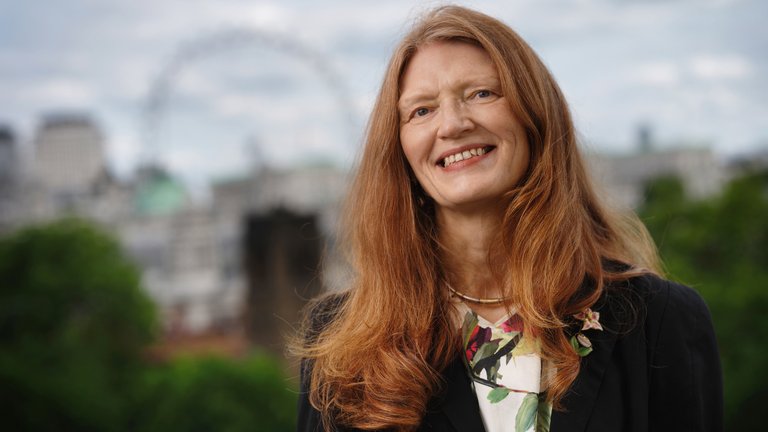 A portrait of Professor Susan J Smith with the London skyline in the background