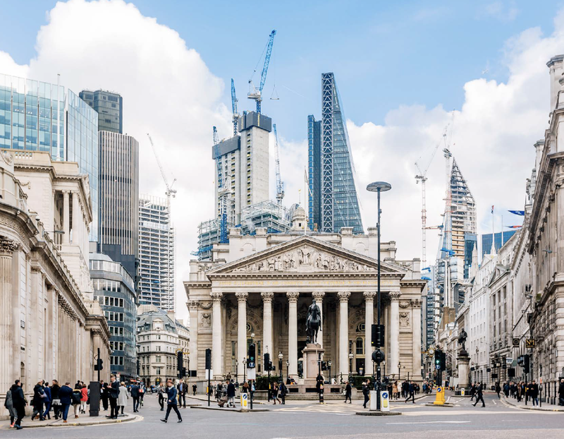 Businesspeople walk in front of the Royal Exchange and the Bank of England in the City of London