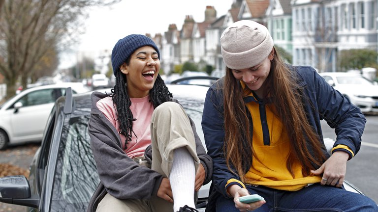 Two girlfriends laughing and hanging out together.