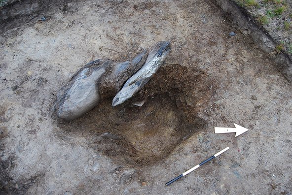 The photograph shows the lifted stone on the ground, which reveals a hole underneath.