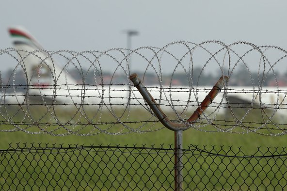 A passenger jet taxis past a security fence. Photo by Cameron Spencer/Getty Images