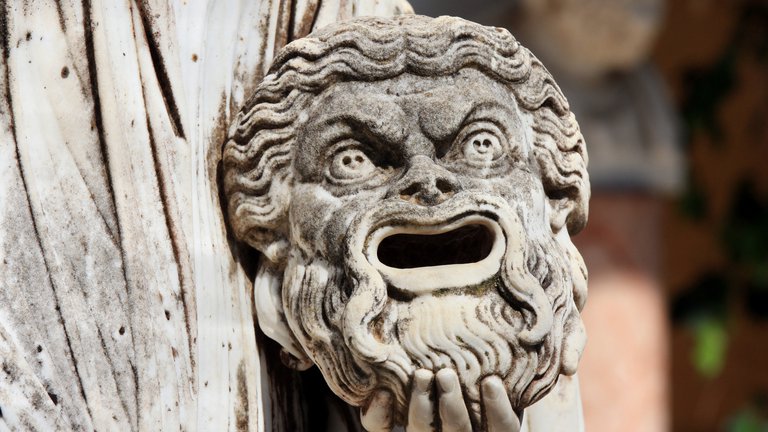 Tragic mask in hand of Greek statue of Melpomene
