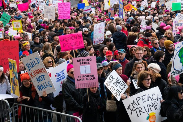 Demonstrators holds signs saying