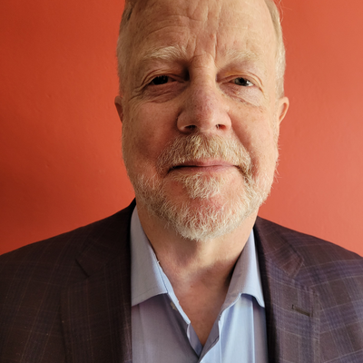 Portrait photo of Professor Vernon Henderson FBA with a dark red background