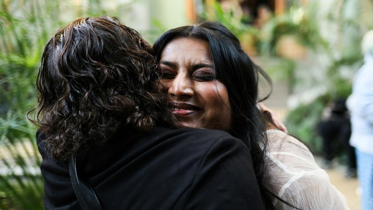 Two women of colour hugging and smiling