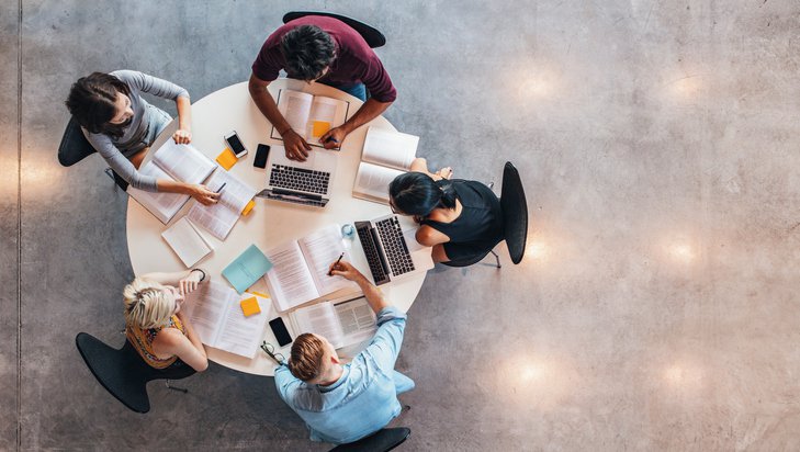 A group of five people working at a table