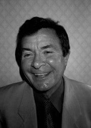 Black and white portrait of Clive Holes smiling