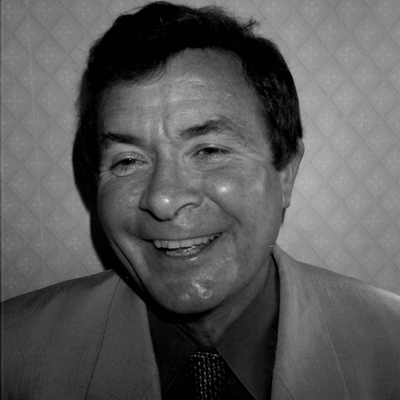 Black and white portrait of Clive Holes smiling