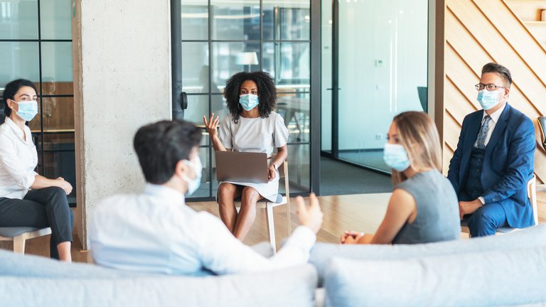 Socially distanced corporate meeting in an office