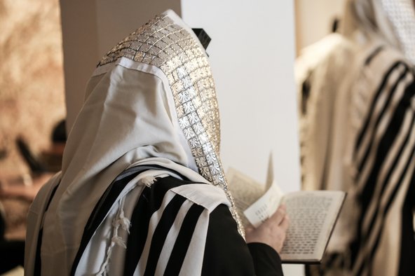 Jewish orthodox man wrapped in prayer shawl from a side view